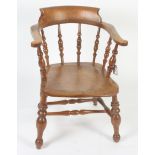 A captain's armchair, late 19th/ early 20th century, with a turned spindle filled back,