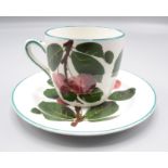 A Wemyss pottery cup and saucer, decorated with the 'Cherries' pattern,