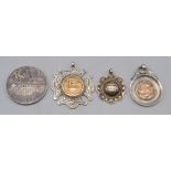 An Edwardian gold mounted silver Gymnastics medal and three other silver sporting medals.