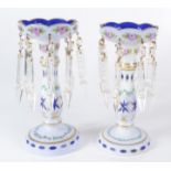 A pair of Bohemian white and blue overlaid table lustres, painted with roses, height 21cm.