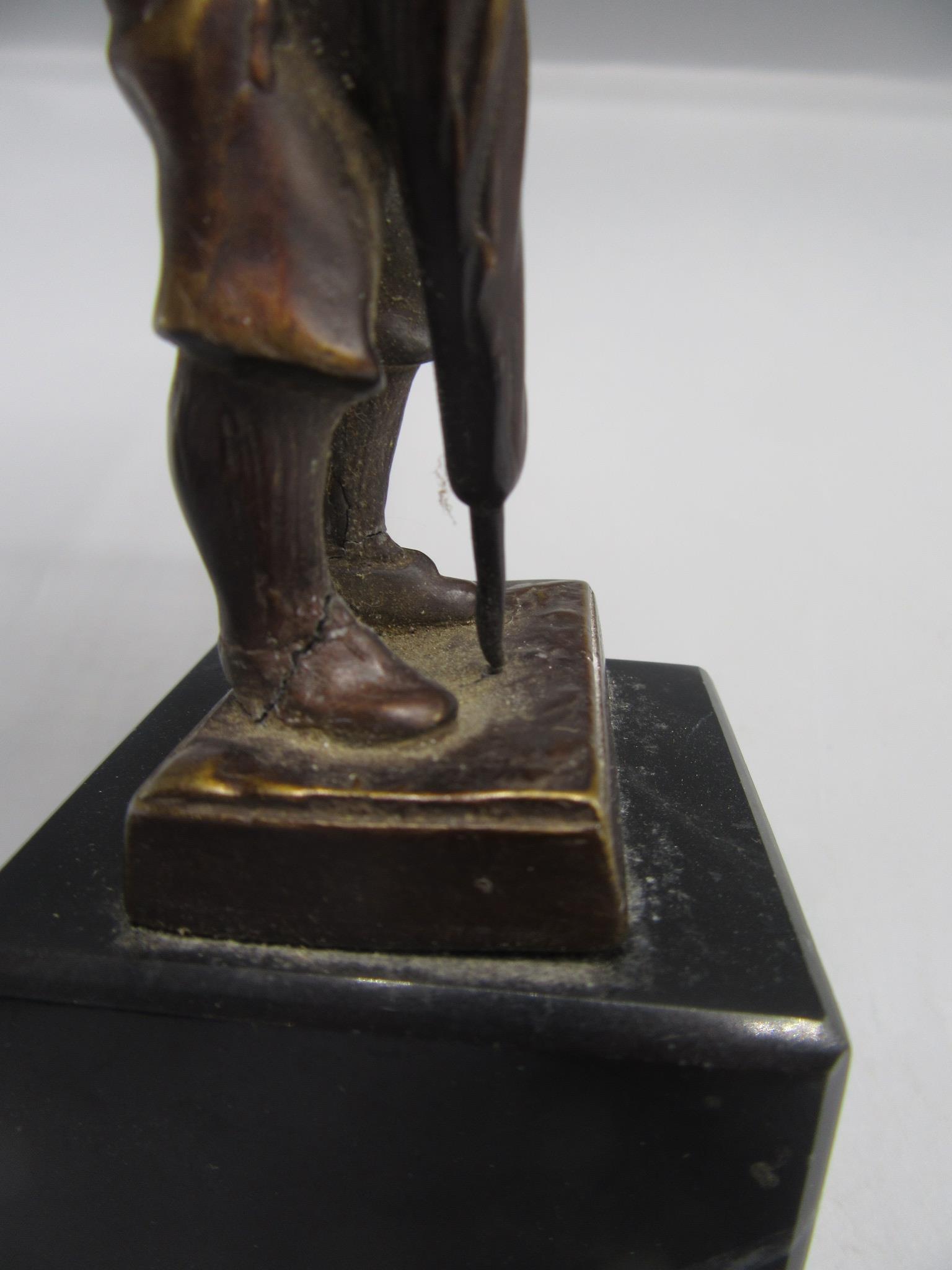 A bronze figure, probably the Artful Dodger, wearing a top hat and raised on a black marble base, - Image 3 of 4