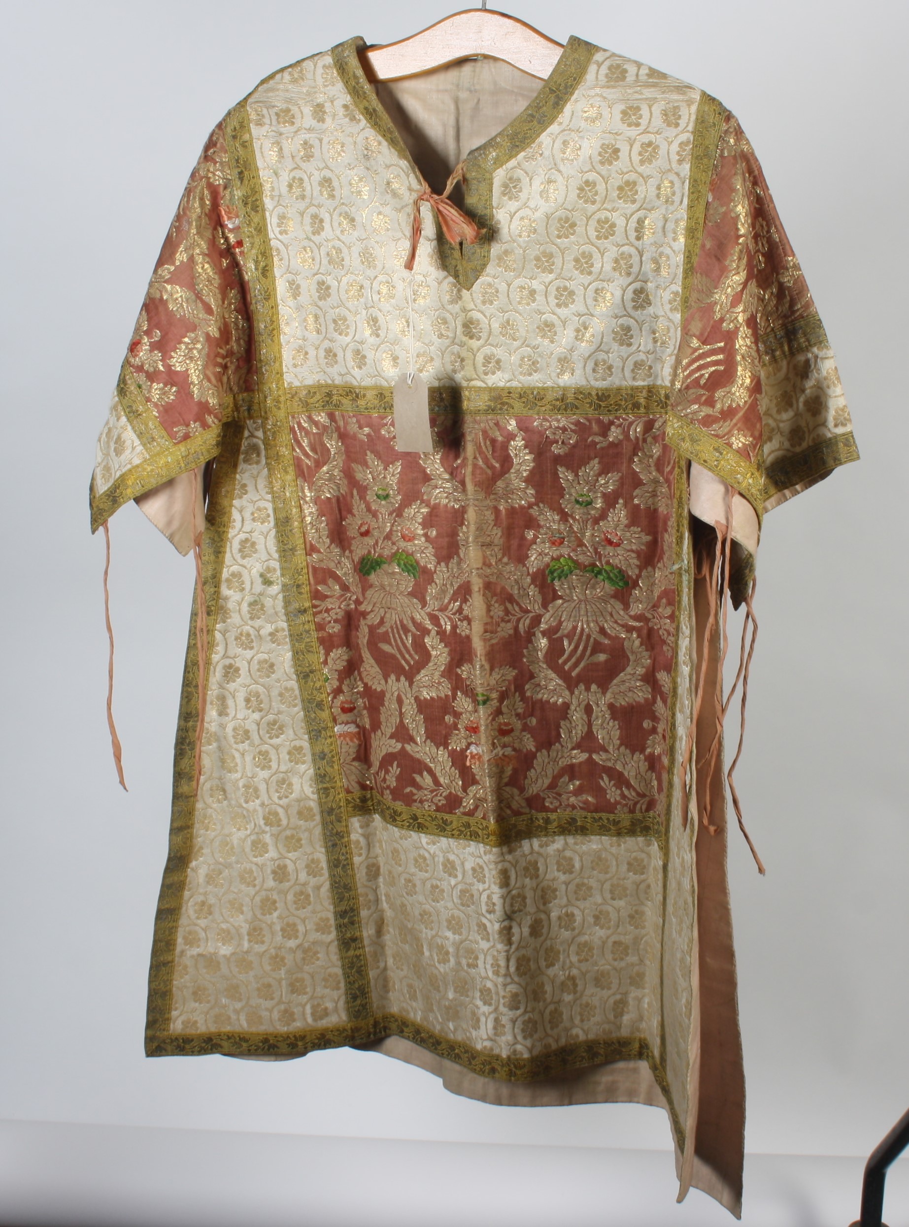 An eastern silk and metal thread over tunic, decorated with floral sprays and leaves, length 101cm.