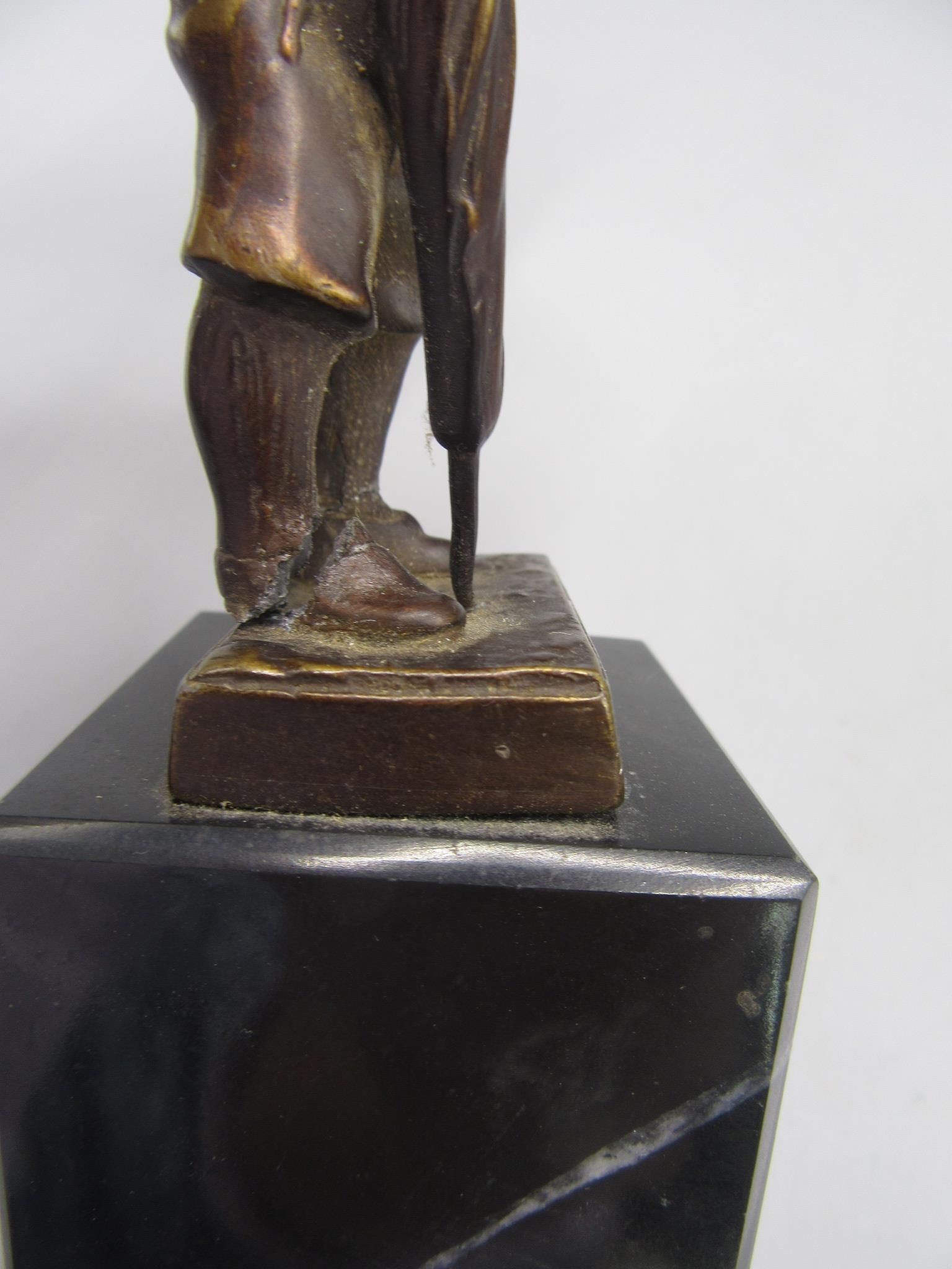 A bronze figure, probably the Artful Dodger, wearing a top hat and raised on a black marble base, - Image 2 of 4