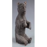 A Black Forest carved wood figure of a bear, with glass eyes, height 23cm.