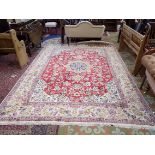 A Persian carpet, the red field with a polychrome medallion with flowering vines,