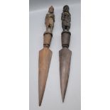 Two African carved wood daggers. each handle in the form of a tribal figure, length 61cm.