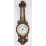 A Victorian carved walnut aneroid barometer,