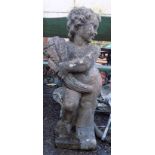 A composition garden statue of a child holding a sheaf of wheat,