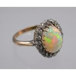 A good opal and diamond oval cluster ring, the claw set opal of approximately 3.5cts.