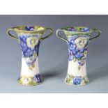 A pair of Macintyre Moorcroft twin handled pottery vases, in the Pansy pattern,