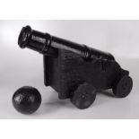 A black painted, cast iron cannon on a wooden carriage, length of cannon 51cm,