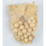 A carved ivory brooch in the form of a bunch of grapes.
