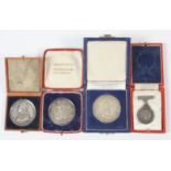 Four silver medallions, each boxed.