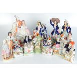 Fourteen Victorian Staffordshire pottery figures and spill vases, height of tallest 34.5cm.