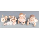 Five bisque porcelain piano babies, largest length 24.5cm.