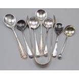 Silver condiment spoons and sugar tongs.