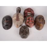 A collection of six miscellaneous carved wood tribal masks, from Kerala, Rajasthan, Guatemala,
