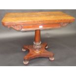 A Regency rosewood card table, the swivel top on an acanthus leaf carved stem, shaped platform base,