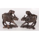 A pair of Chinese hardwood figures of buffalos, each with a male rider, early 20th century,