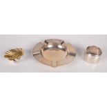 A silver parcel gilt shell salt, an engraved silver napkin ring and a silver ashtray, 5.3oz.