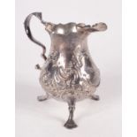An 18th century repousse decorated bellied cream jug with elephant's head crest, London 1792, 2.5oz.