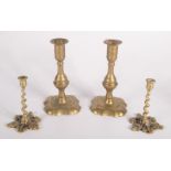 A pair of Georgian brass petal based candlesticks, each with a baluster stem, height 18cm,