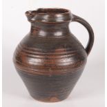 A studio pottery jug, the ribbed body with tenmoku glaze, height 21.2cm, width 20cm.