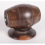A treen string box, late 19th/early 20th century in the form of a barrel on a circular plinth base,