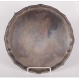 A shaped silver tray with gadrooned border on four ball and claw feet by the Goldsmiths &