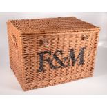 A wicker twin handled picnic basket, black painted F&M to the front, for Fortnum & Mason,