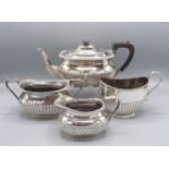 A spiral fluted and gadrooned three piece tea service and a half fluted sugar bowl.