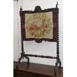 A mahogany and woolwork firescreen, 19th century, the panel depicting a large floral spray,