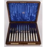 A set of twelve silver dessert knives and forks by the Goldsmith & Silversmiths Co Ltd with mother
