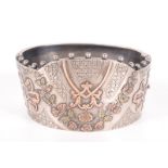 A good Victorian Revivalist silver cuff bangle with beaded fringe and applied three colour gold