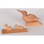 A carved wood figure of a duck by Wharton Lang, height 15cm, width 23cm, and another of ducklings,