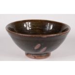 A Trevor Corser Leach pottery footed bowl, the tenmoku glaze with abstract decoration,