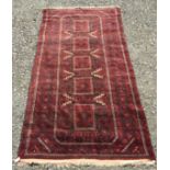 A Belouch rug, with five central medallions each filled with hooked guls, within multiple borders,