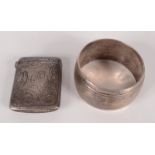 A late Victorian engraved silver vesta case and a silver napkin ring.