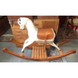 A white painted wood rocking horse with leather saddle, height 89.5cm, width 35.5cm, length 136cm.