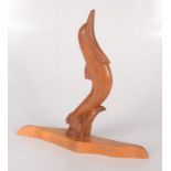 A carved wood figure of a dolphin by Wharton Lang, monogrammed, height 32.5cm.