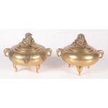 Two Chinese polished bronze censers, each surmounted by a dog of fo, height 10.5cm, width 13cm.