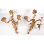 A pair of Rococo style gilt metal three branch wall lights,