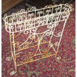 A wrought iron, white painted plant stand,