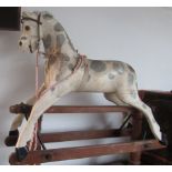 A white and dapple grey painted wooden rocking horse, height 87cm, width 36cm, length 91cm.