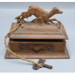 A Black Forest musical jewel box, late 19th century, the carved wood case surmounted by a deer,
