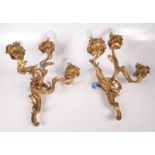 A pair of Rococo style gilt metal three branch wall lights,