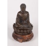 A Thai bronze figure of a seated Buddha on a lotus throne, on a carved hardwood stand, height 14cm,