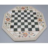 An Indian Agra inlaid marble octagonal chessboard, decorated with flowering trees, 38 x 38cm.