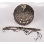 An African circular tribal wooden mask, mounted with brass, shells and beadwork, 30 x 28cm,