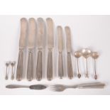 Four German 800 standard dinner knives with filled silver handles and a pair of matching dessert
